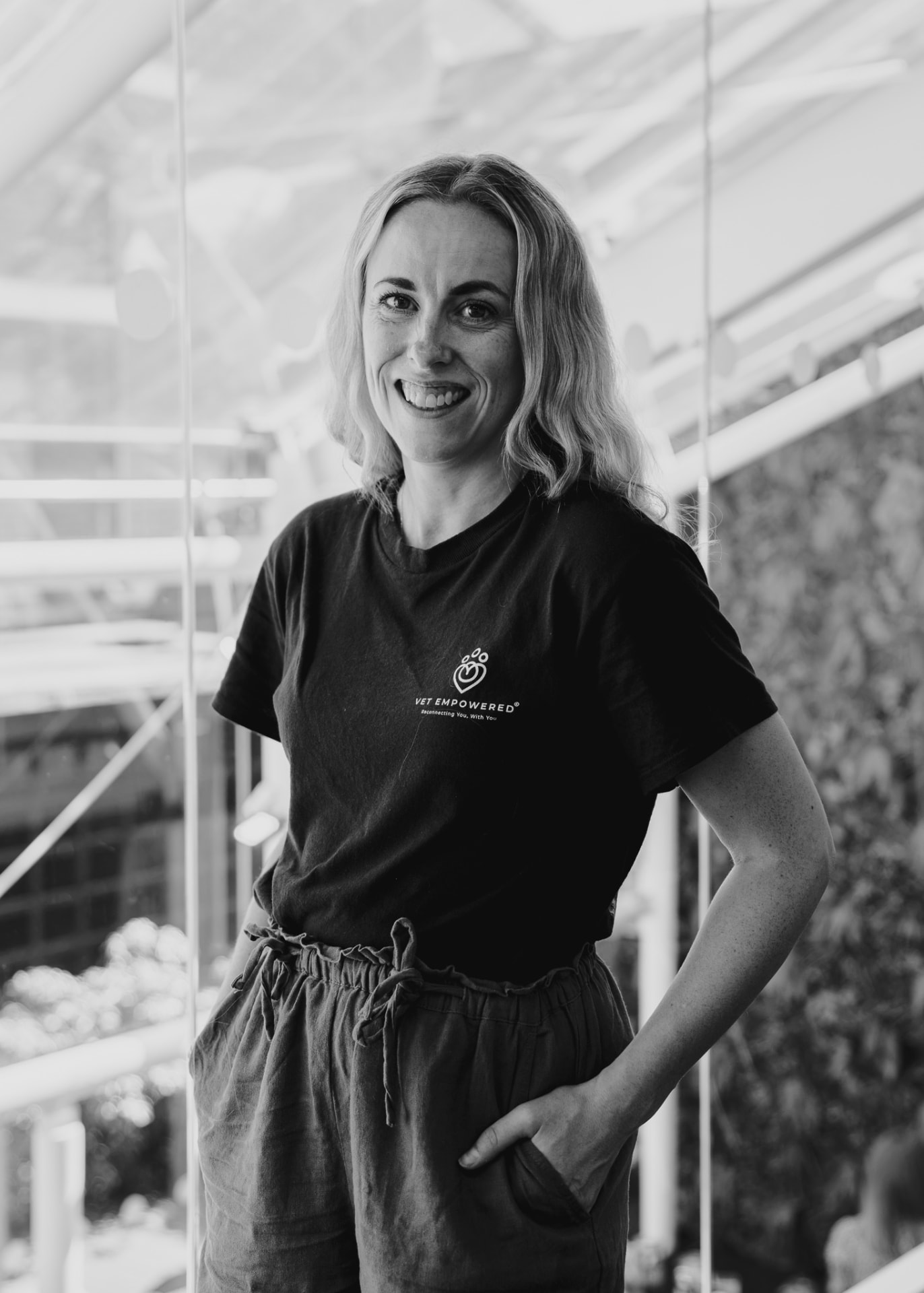 Black and white portrait of Katie Ford, veterinary surgeon and co-founder of Vet Empowered, smiling to camera